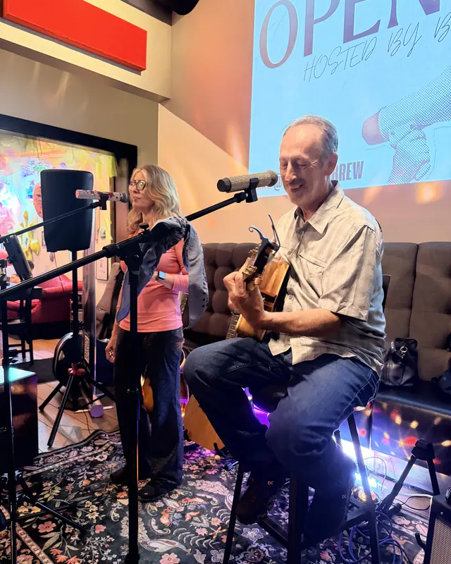 Guitarist and singer performing together at an open mic
