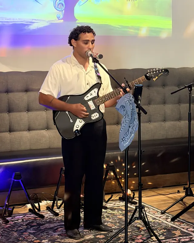 Guitarist playing electric guitar at an open mic
