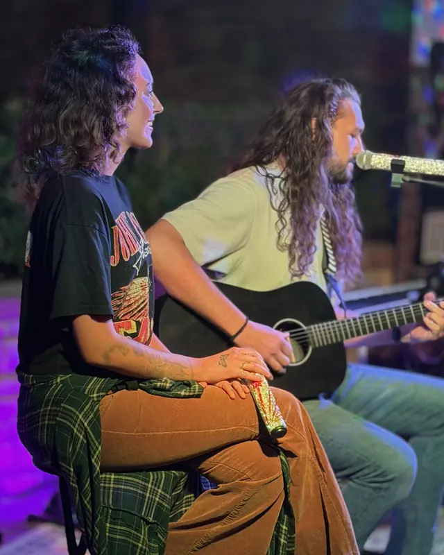 Two performers sharing the stage at the open mic