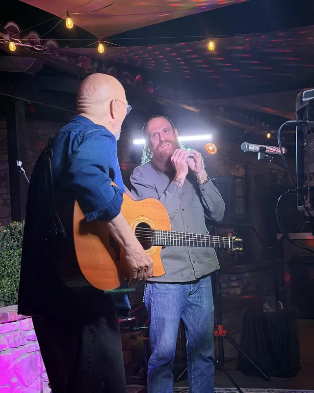 Guitarist and harmonica player performing together at the open mic