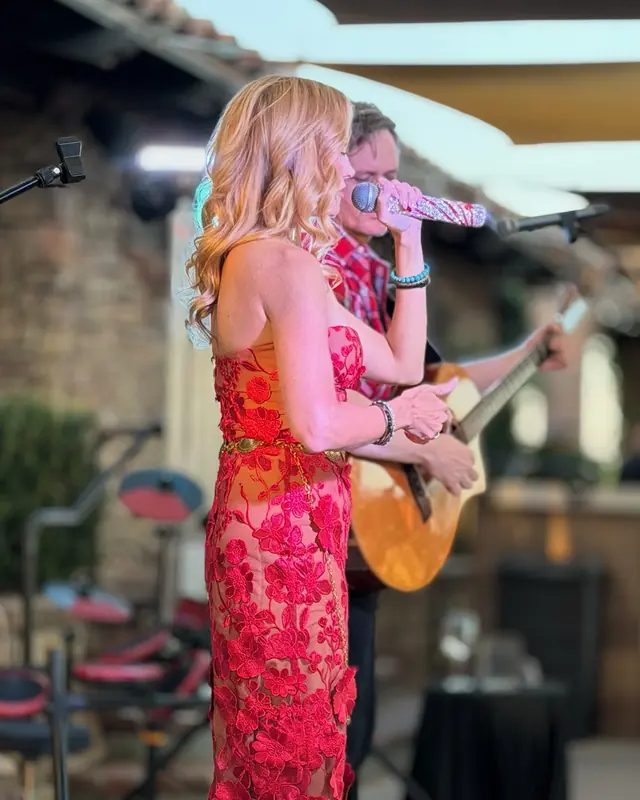 Singer in a red lace dress performing with a guitarist at the open mic